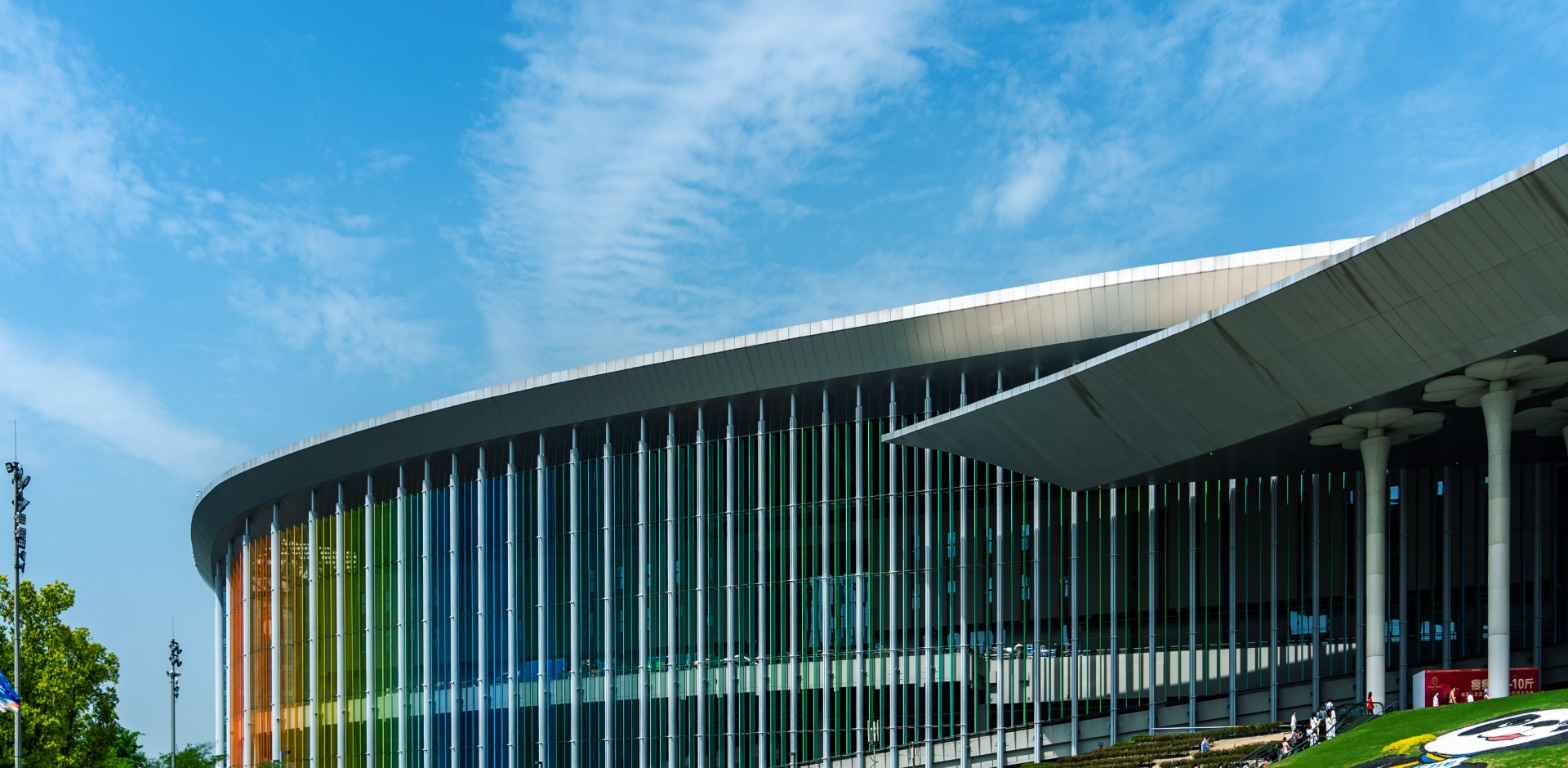 Exterior view of a modern expo center with colorful glass panels, hosting the Solavita showcase, emphasizing innovation in renewable energy solutions