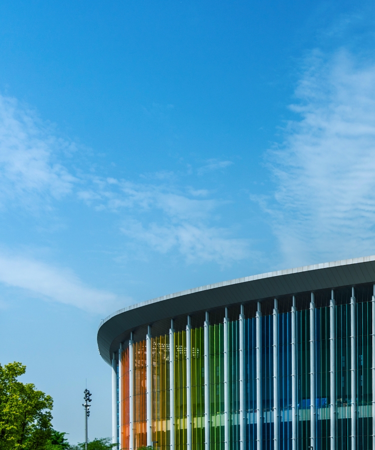 Exterior view of a modern expo center with colorful glass panels, hosting the Solavita showcase, emphasizing innovation in renewable energy solutions