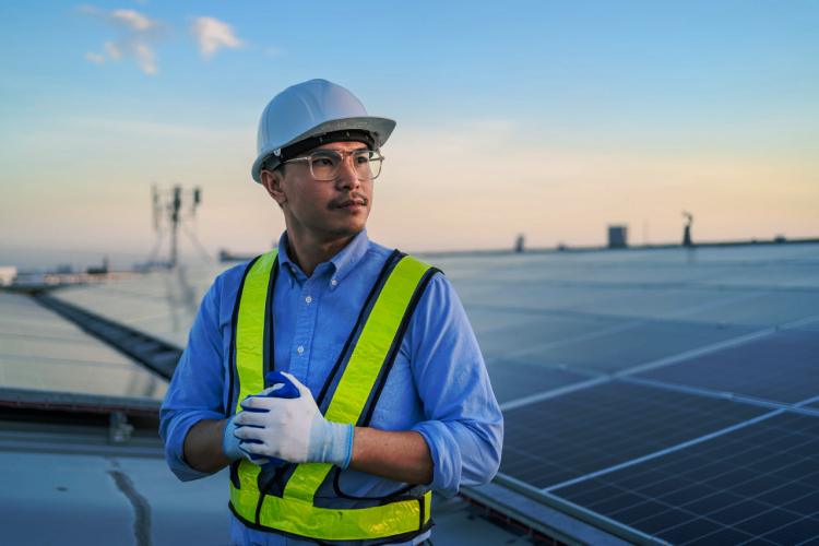 Engineer in safety gear inspecting Solavita inverter installation on a solar panel array, focused on ensuring optimal system performance.